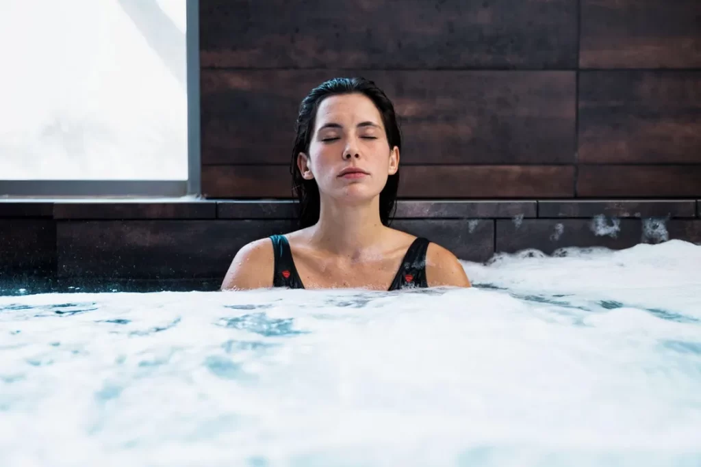 Woman relaxing in a hot tub with eyes closed during a private spa experience